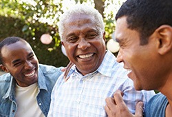 Three men outside laughing and talking together