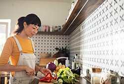 Woman in yellow shirt chopping vegetables