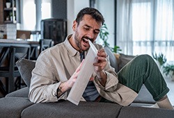 Man opening plastic envelope package with teeth