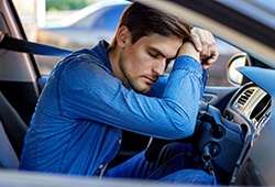 Man asleep at the wheel of car