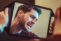 Man looking at smile in mirror