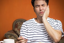 Man in pain holding jaw