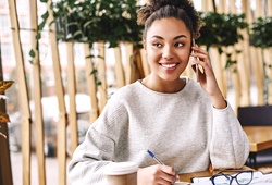 person smiling and speaking on their phone