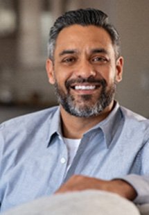 Man smiling while relaxing on couch at home