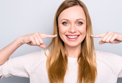 Woman pointing to her smile