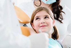 Smiling young girl in dental chair