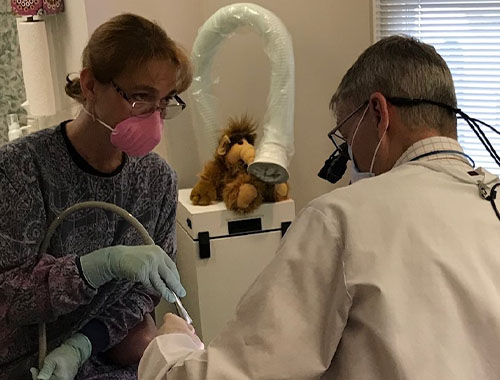 Dentist and team member treating dental patient