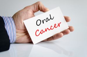 Man’s handing holding card that says Oral Cancer