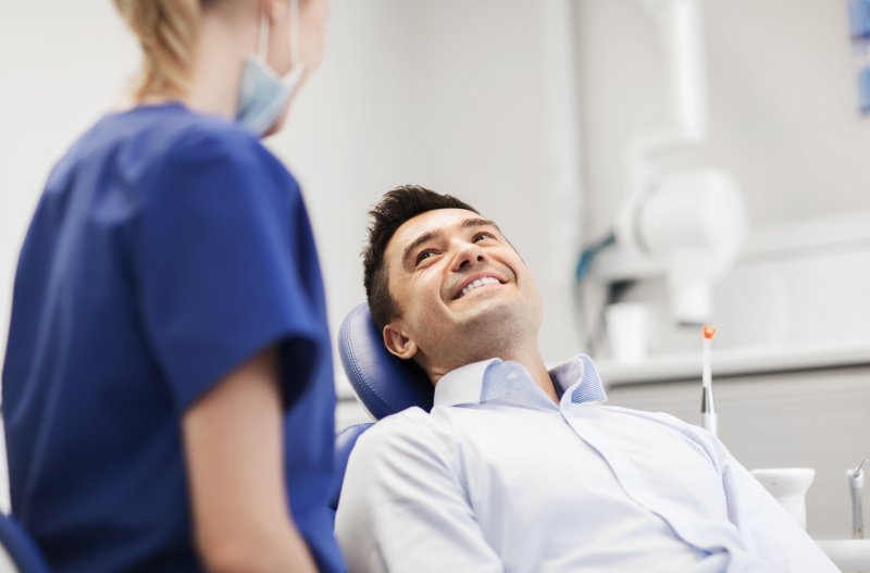 A dentist talking with her patient about his good oral health