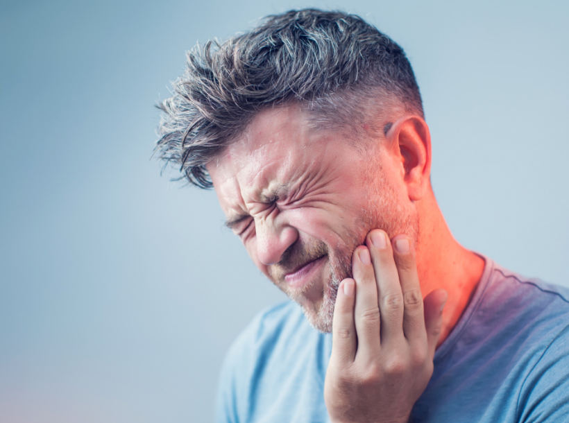 Man holding jaw in pain