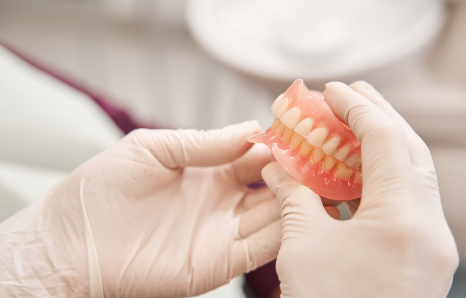 Dentist holding dentures