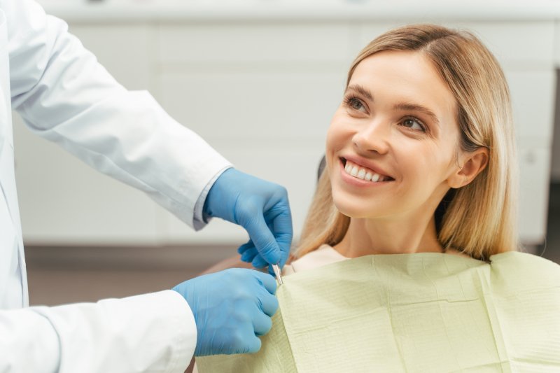 a patient smiling while visiting her dentist