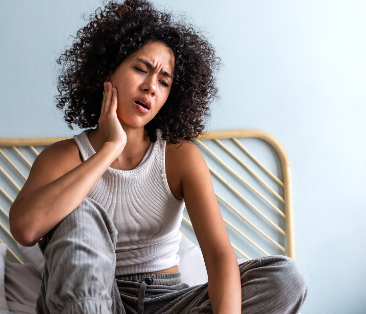 Woman holding jaw in pain